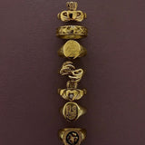 A vertical stack of seven Irish gold signet rings with various heraldic and decorative engravings, displayed on a textured dark plum background.