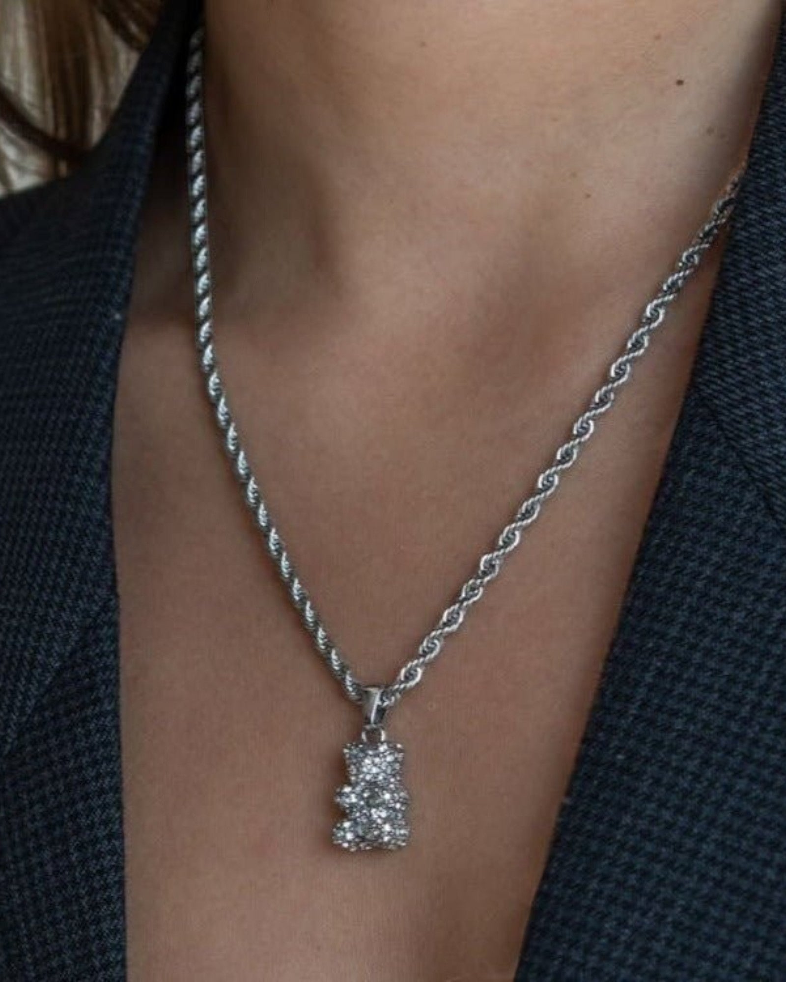 Réalta silver-tone pavé bear pendant necklace on a twisted rope chain worn around a neck.