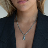 Réalta silver-tone pavé bear pendant on a delicate rope chain worn by a woman in a dark blazer